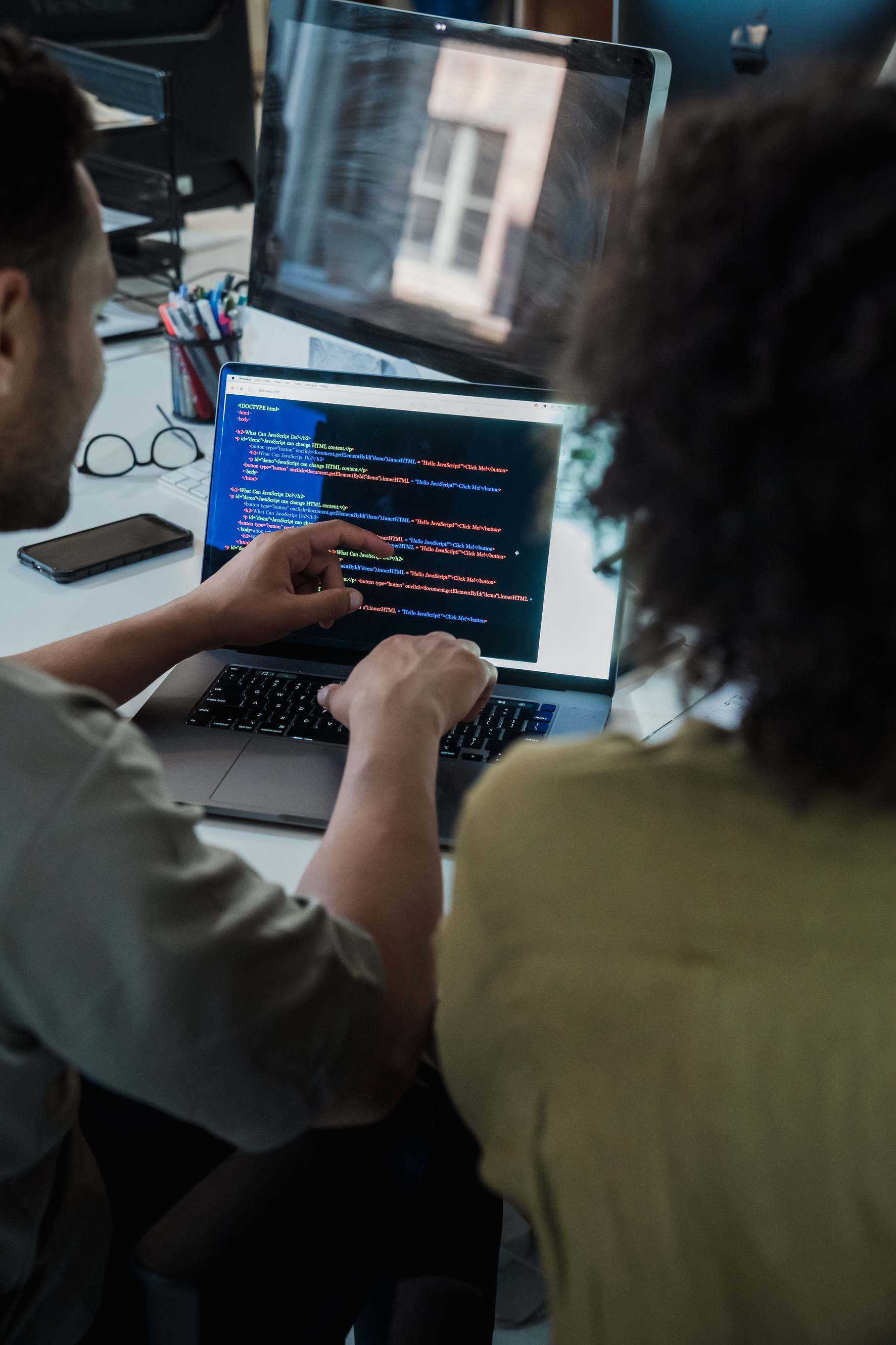 Laptop showing source code during a debugging session in an office